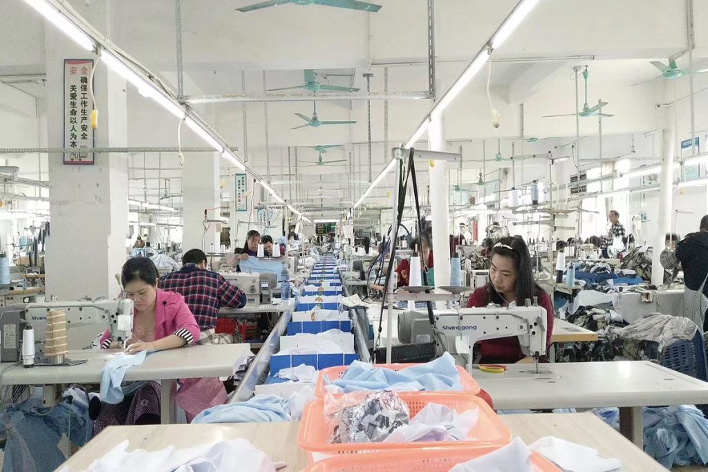 Inside garments factory,workers using seam machine to work